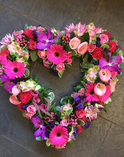 Heart SYM-325 - A beautiful open heart made with a selection of pink flowers specially chosen to make a stunning tribute by our florists.